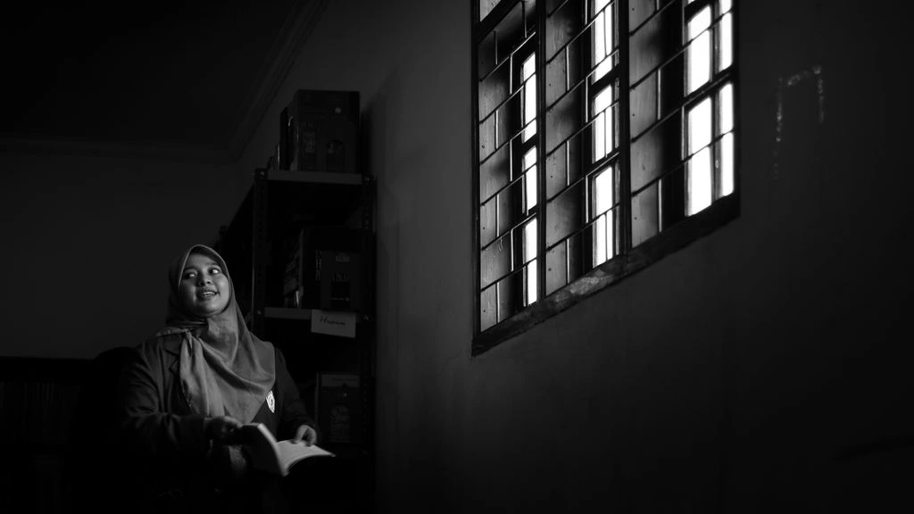 A quiet reading room at dawn, lit by a single window
